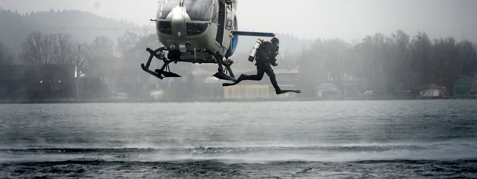 Polizeitaucher springt aus Hubschrauber
